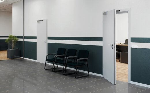 In the event of an alarm, people leave an office building through an emergency exit door.