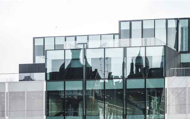 Glasfassade mit Spiegelung historischer Architektur
