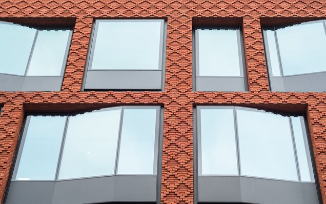 Fassade mit roten Ziegeln und Fenstern