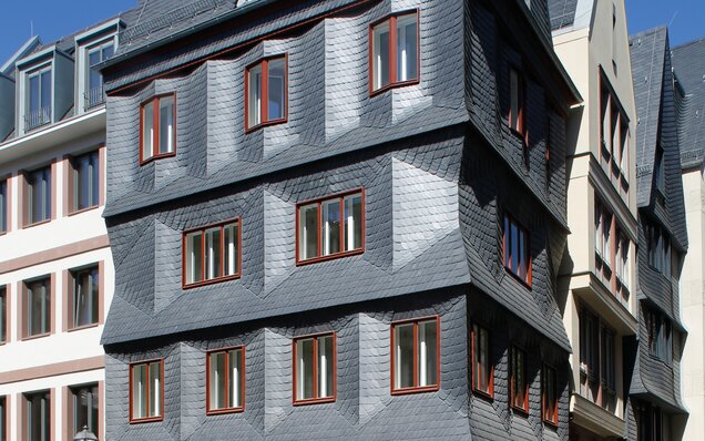 Fassade mit Schieferplatten und Holzfenstern